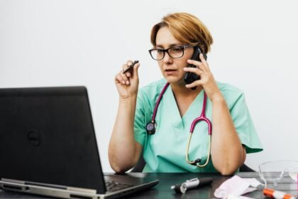 Médica com estetoscópio trabalhando em laptop no consultório, usando IA para médicos